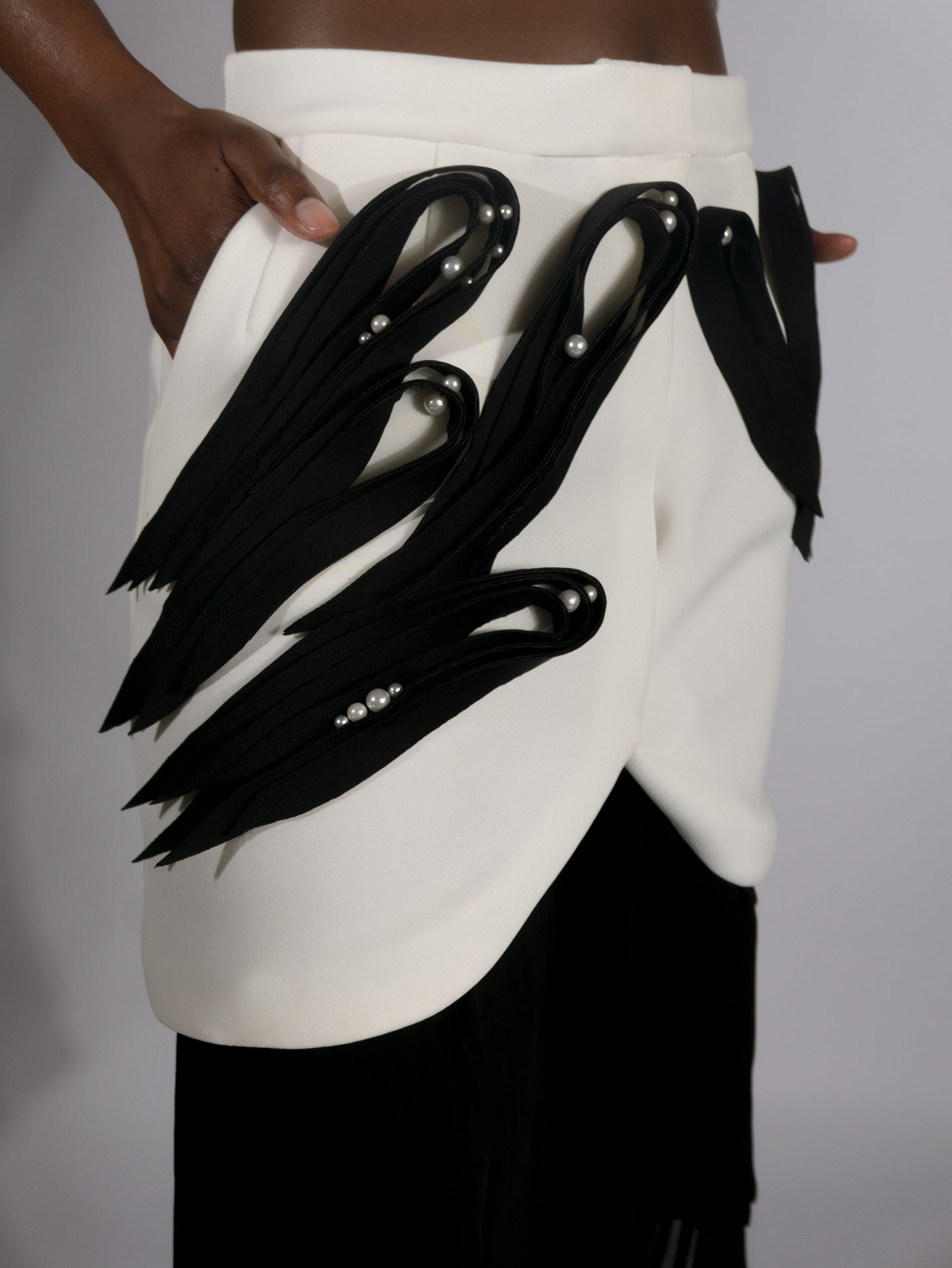 ARGO, jupe plissée asymétrique avec application en néoprène façon quilling